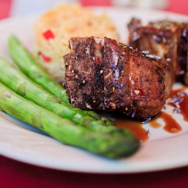 A plate of asparagus, meat, and pasta.