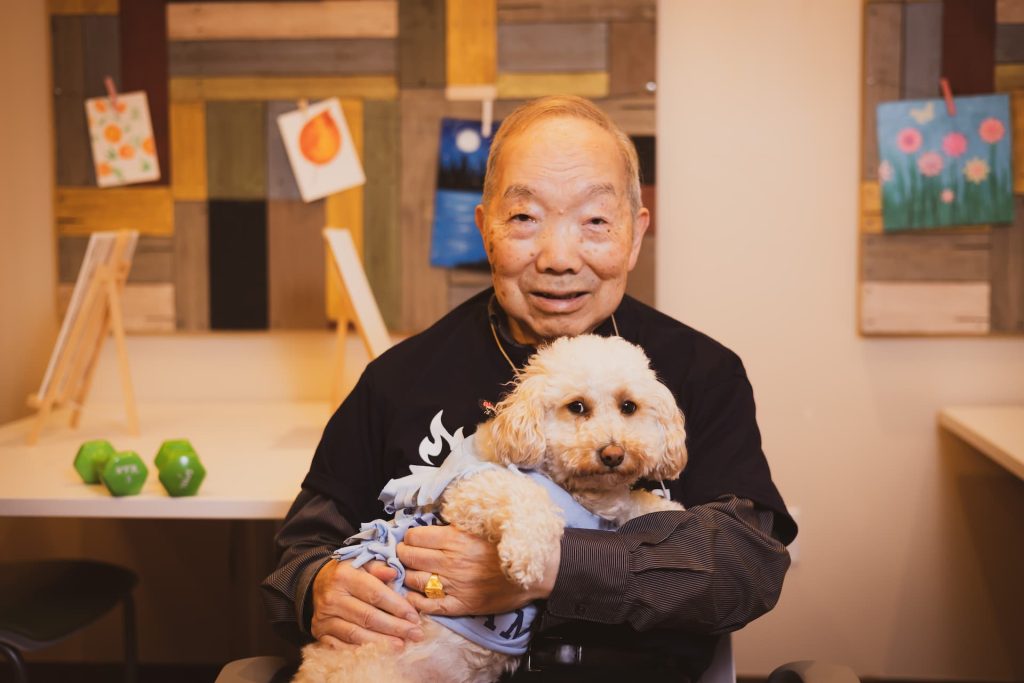 Senior male holding a dog