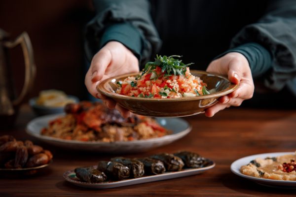 Hands putting a plate of food down on a table