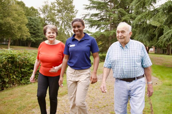 Two residents walking outside with an employee