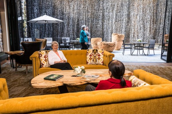 Two residents sitting on yellow couches