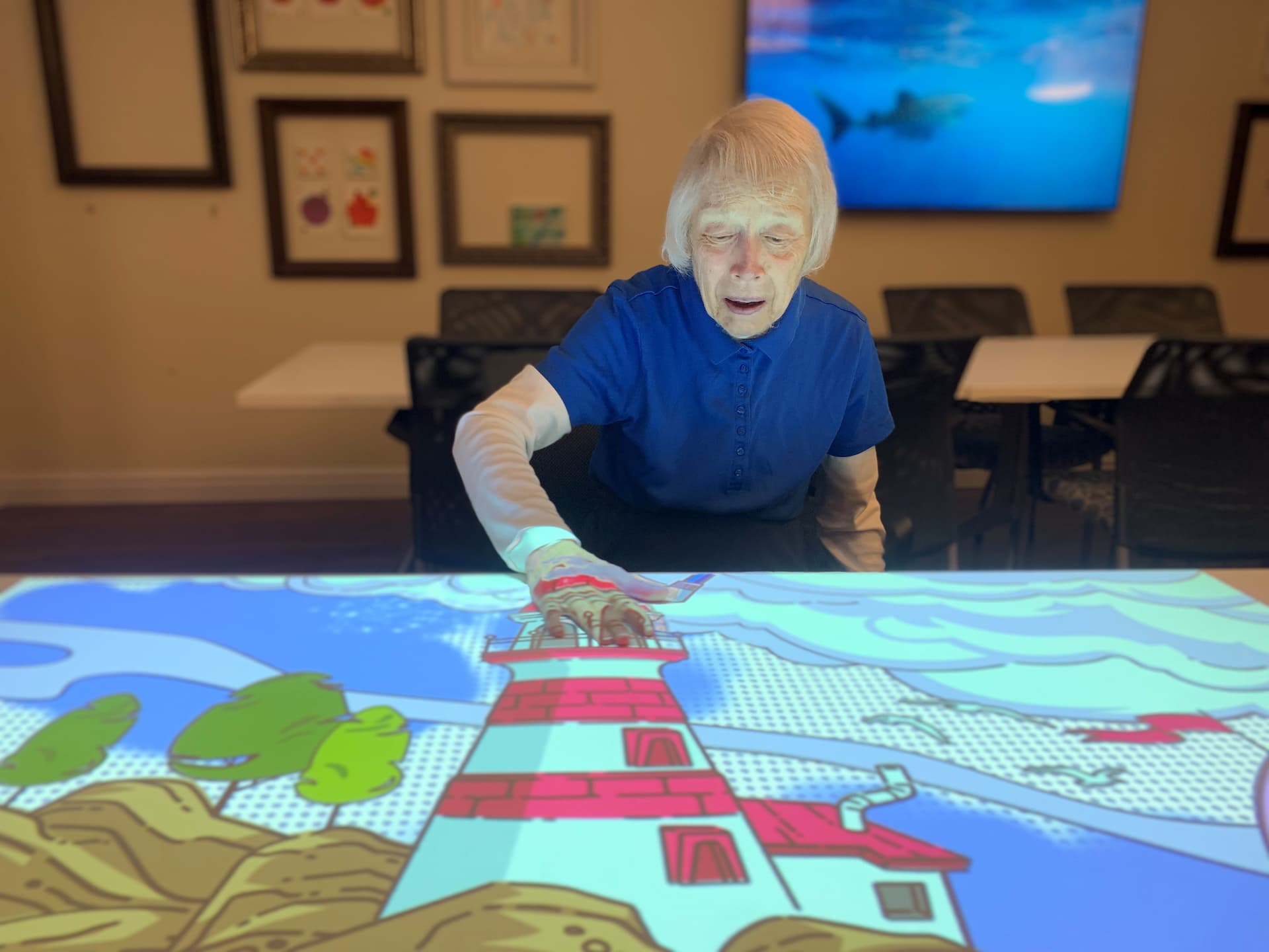 A resident touching a picture of a lighthouse