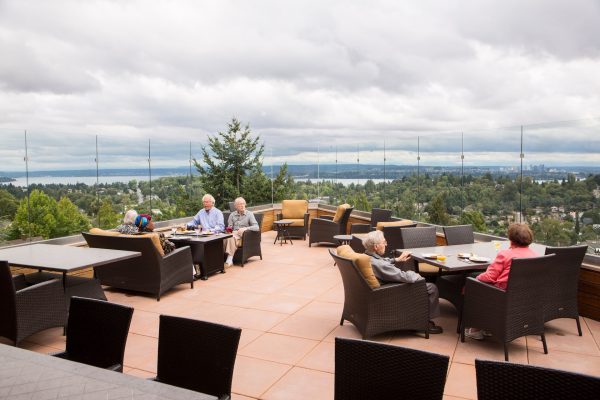 Residents sitting, talking on the Aegis Living Madison rooftop