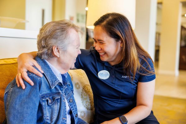 An employee putting their arm around a resident