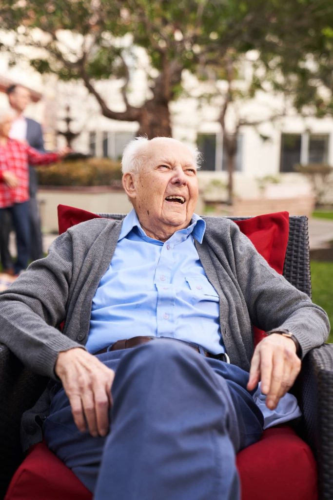 A resident sitting outside, smiling