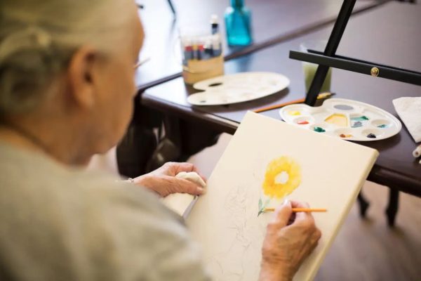 A resident painting a yellow flower