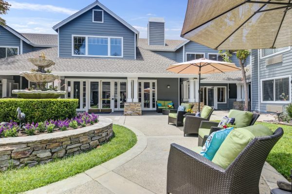 An outdoor seating area along a path to the entrance of Aegis Living