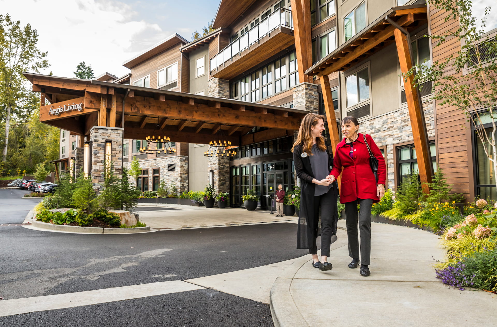 A resident and an employee walking outside of the main entrance