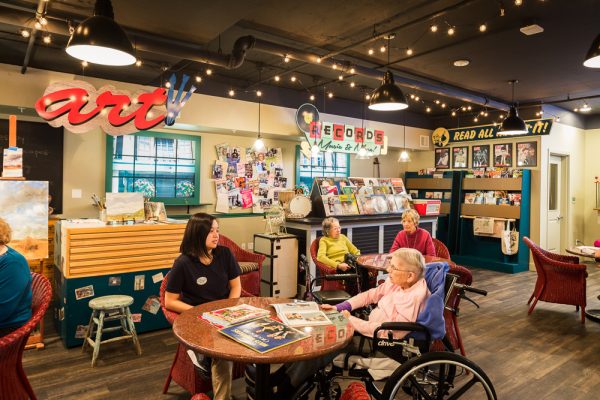 Residents sitting, playing games, and reading in the Pike Place–themed room