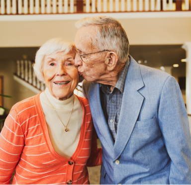 A resident giving another resident a kiss on the cheek