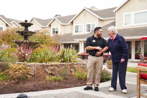 An employee walking outside with a resident.