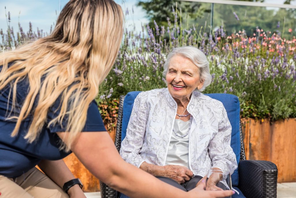 An employee handing a resident a glass of wine