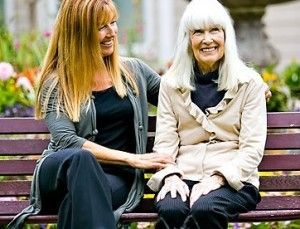 middle-aged woman and elderly woman together on park bench