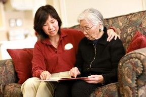 aegis garden care staff reading with a community resident.