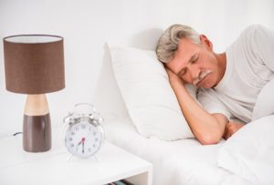 elderly man sleeping in white bed