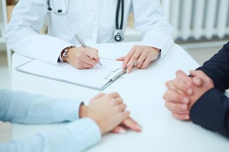 an elderly couple talking to a doctor