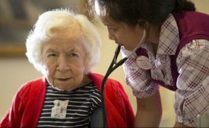 An Aegis of Living resident watches a staff nurse check her vital signs