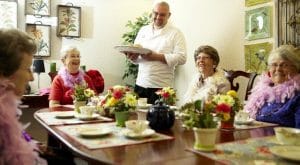 Ladies dressed in feathered boas for tea time at Aegis of Lynnwood