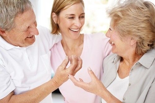 two senior parents hugging their daughter in the image