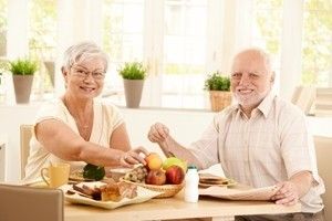 Senior couple eating breakfast by the window.