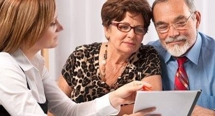 a woman going over a financial statement with a senior couple.