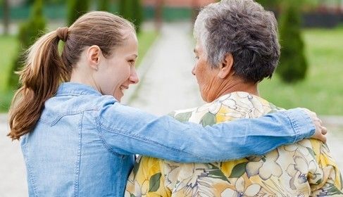 a young woman and elderly woman walking side by side.