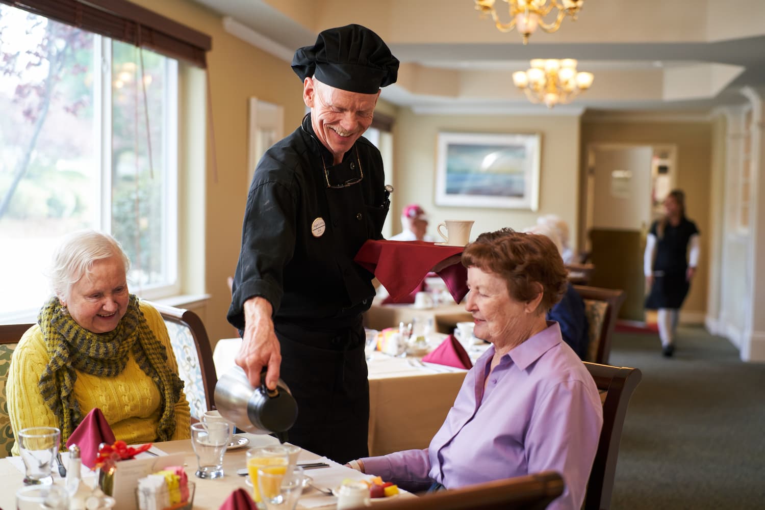 Two residents being served breakfast