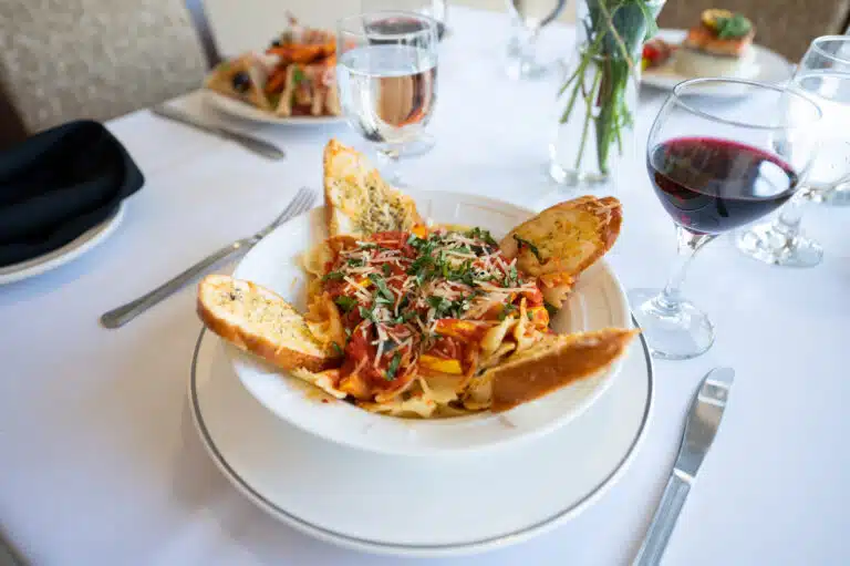Pasta dish with garlic bread and wine