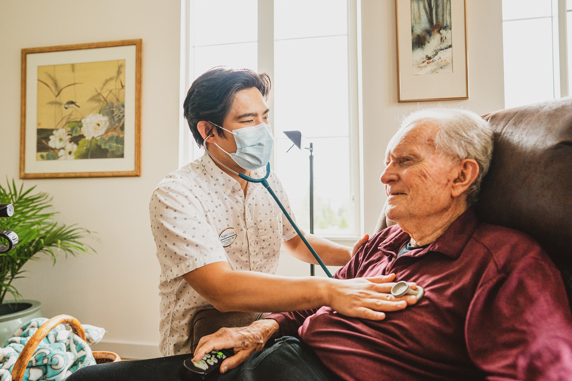 Healthcare worker checking elderly patient's heartbeat.