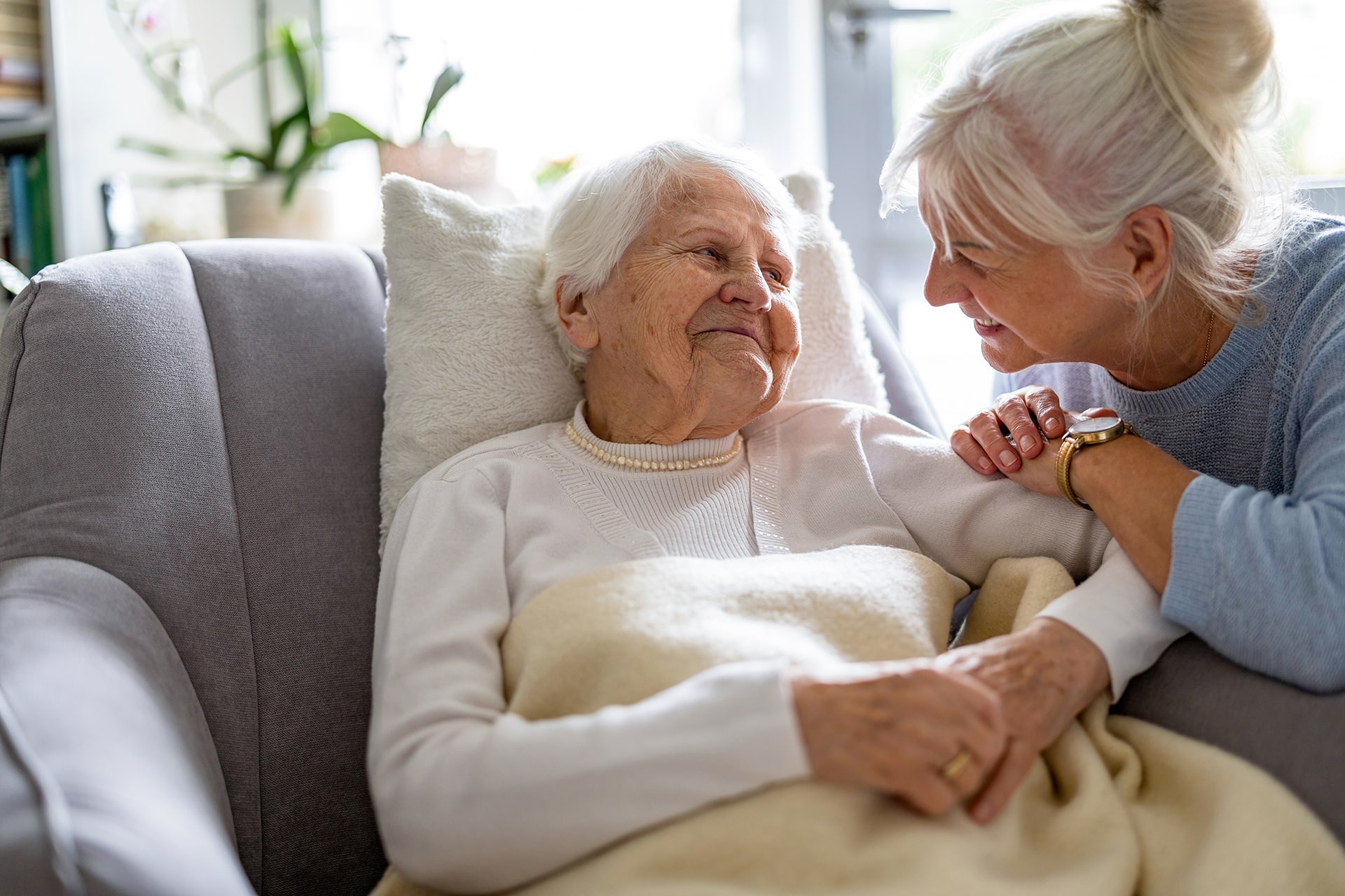 Elderly woman and caregiver sharing a comforting moment.