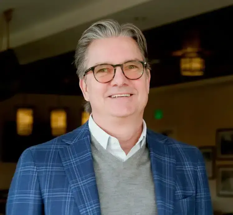 Smiling man in blue plaid suit and glasses